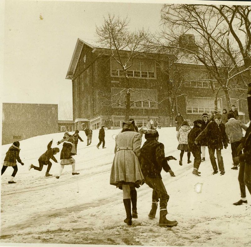 Two views of children playing outside the William Smith School:
a. in the snow in front of the school
b. on playground equipment in front of the school