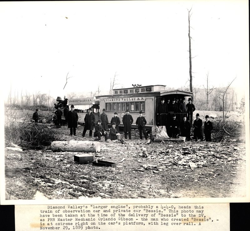 Passenger car of the Diamond Valley Railroad with passengers posing on and around the car and engine